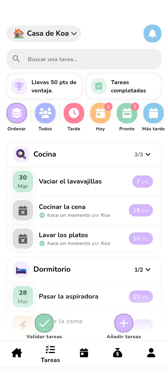 Pantalla de tareas de Koabit: lista de tareas de la Casa de Koa organizadas por habitación (Dormitorio, Cocina), cada una con su valor en puntos (5, 7, 15 pts), y un distintivo «Llevas 25 pts de ventaja» que compara a los miembros del hogar en tiempo real